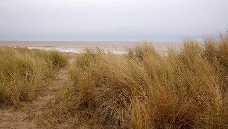 Mirando-A-Través-De-Las-Dunas-De-Arena-Marram-Hierba-Con-El-Mar-Más-Allá-En-Ingoldmells,-Skegness-Beach