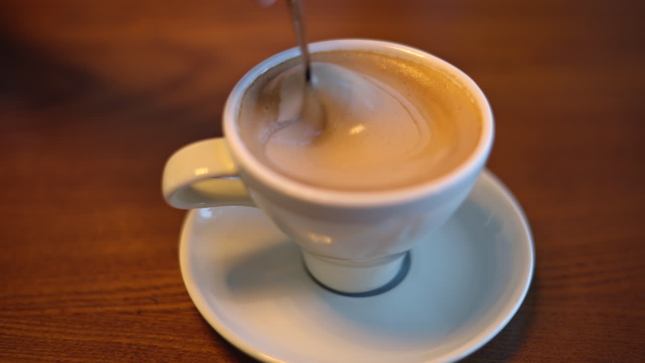 Woman hands stiring coffee foam