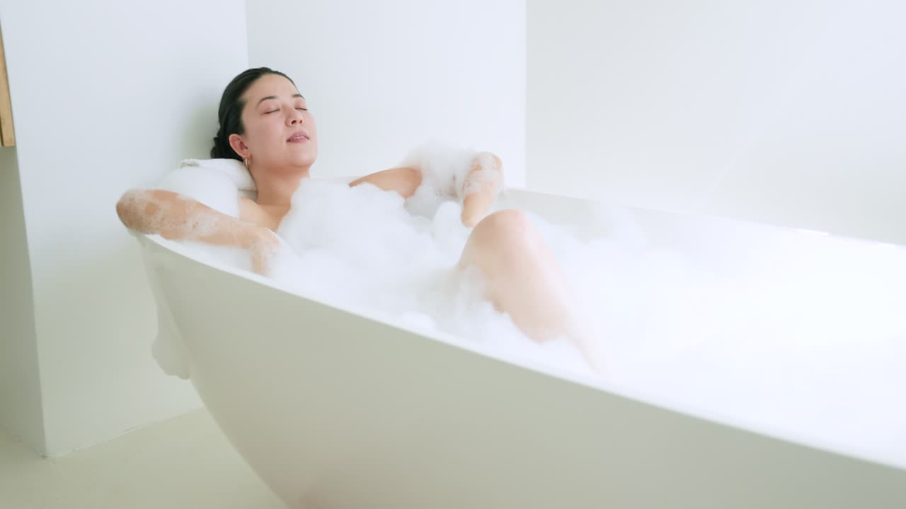カメラが焦点を合わせると、浴槽にゆったりと身を横たえ、腕を縁にかけ、泡に包まれながら安らぎを求めている女性が写し出された。