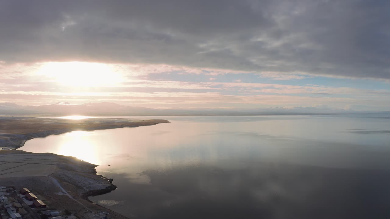volando sobre la ciudad paisajística del fiordo occidental de islandia al atardecer, vista aérea escénica del océano ártico, reflejo surrealista del paisaje nuboso