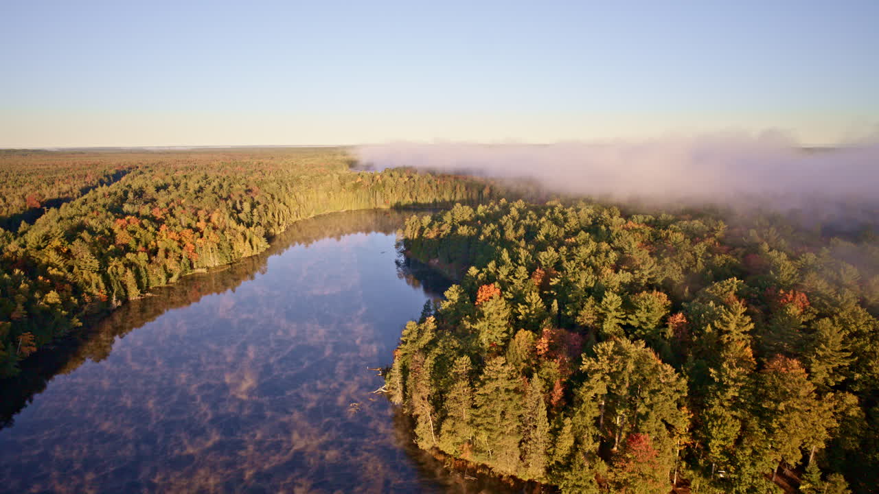 Drone captures sunrise haze lifting from a reflective water surface