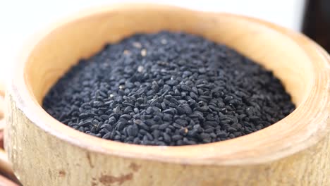 black cumin seeds in wooden bowl