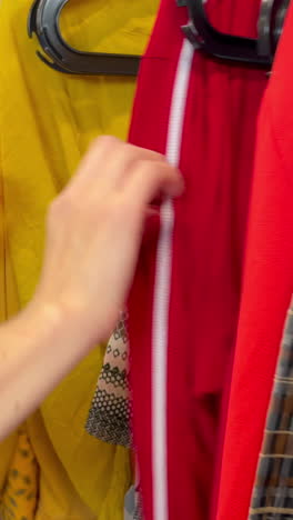 shopping for clothes coats and sweaters on a hanger in a store shopping for clothes coats and sweaters on a hanger in a store winter womens fashion clothes discounts in the store