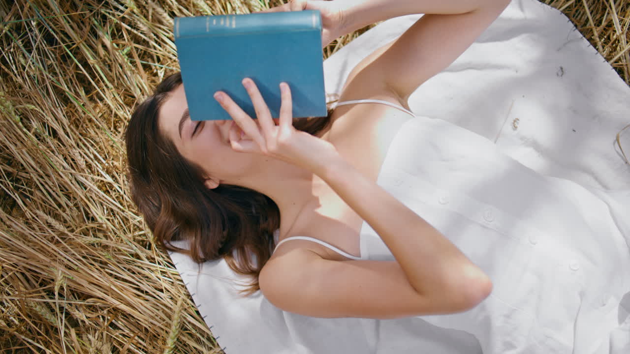 행복한 여자가 을 고 선샤인 메도 (sunshine meadow) 에서 책을 들고 있다. 웃는 여자