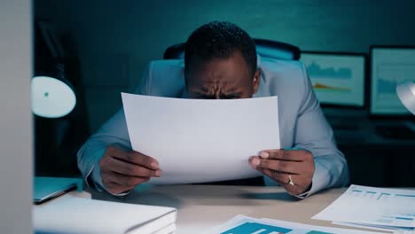 stressed businessman reviewing documents at night