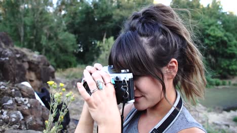 handheld footage of a cute hipster girl talking and messing around with a camera