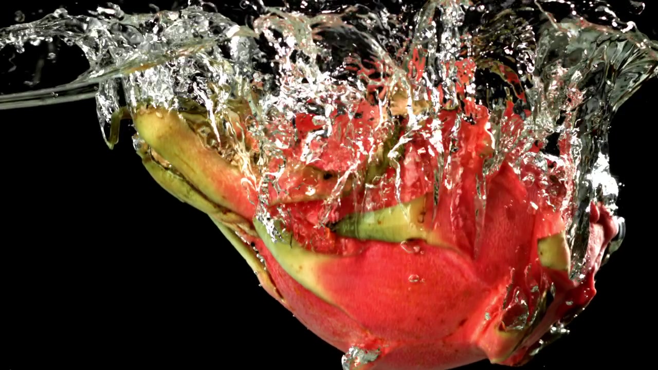 Red Dragon Fruit Splashing into Clear Water in Slow Motion