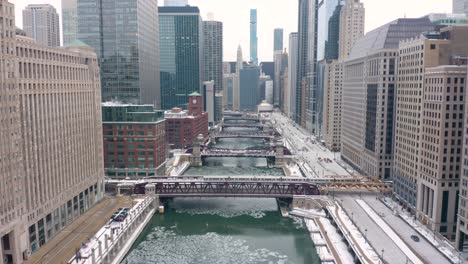 aerial descending shot above chicago river - subway train crossing bridge to enter loop