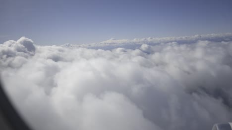 white cloudscape stretching across horizon, revealing soft, fluffy layers viewed from high-altitude flying perspective, creating dreamlike aerial panorama