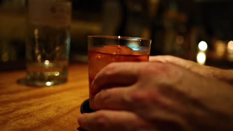 sequence of a hand grabbing a drink at a bar