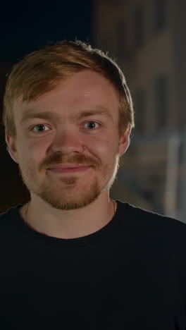 man smiling and giving thumbs up at night