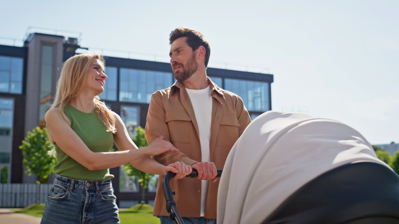Young family peaceful walk baby in stroller at greenery closeup. Happy parents