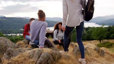 a young adult woman joins her four friends after reaching the summit during a mountain hike,  slow motion