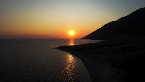 sun setting on the ionian sea horizon reflects golden rays over the beautiful bay in a romantic sunset