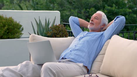 senior man using laptop in the garden 4k