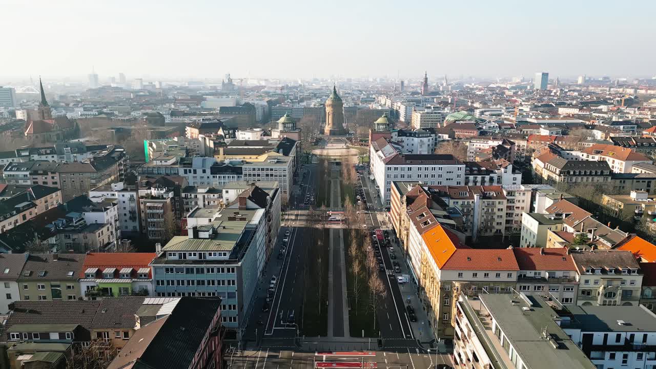 Drone flight over Mannheim's Augustaanlage towards the iconic Wasserturm on a clear, sunny winter day.