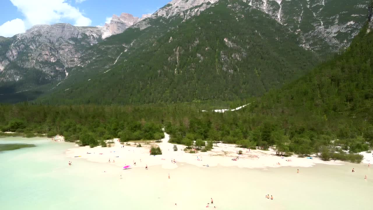 Turisté relaxují a plavou v průzračných vodách Lago di Landro v italských Dolomitech