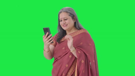 Happy-Indian-old-woman-scrolling-through-phone-Green-screen