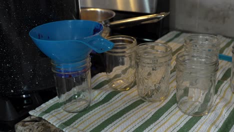 Pouring-hot-raspberry-and-blueberry-jam-into-jars-to-preserve-and-seal