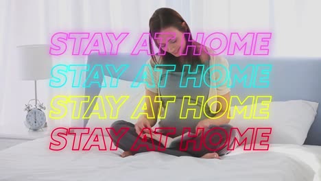 Animation-of-four-lines-of-colourful-neon-words-Stay-At-Home-over-pregnant-Caucasian-woman-reading-b