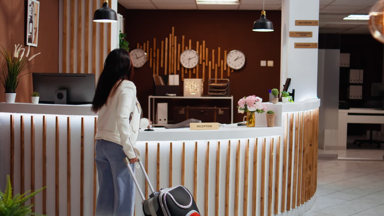 mujeres asiáticas llegando a la recepción vacía del hotel y sonando la campana