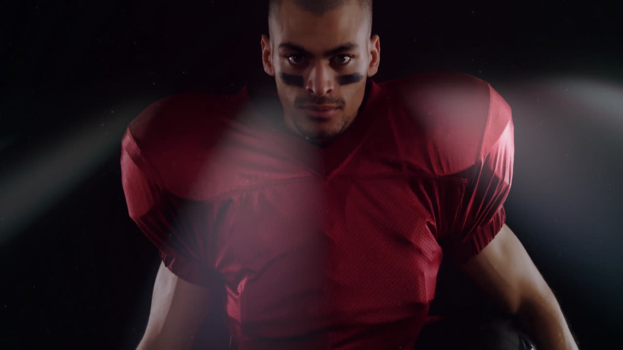 Preparing for game, football player in red jersey showing intense focus