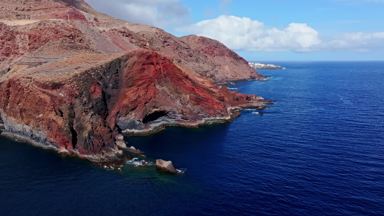 Aerial of rugged red cliffs on El Hierro coast by blue Atlantic, Spain, Canary
