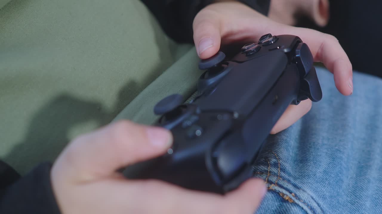 Close-up on person's hands using a video game controller