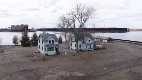 Abandoned,-condemned-homes-sit-vacant-along-waterfront-property-surrounded-by-security-fencing