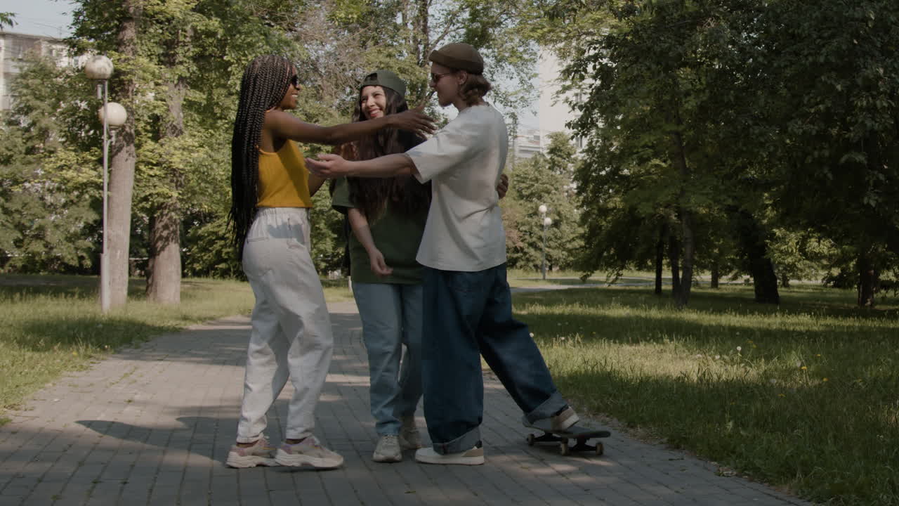 Friends greeting and hugging in a park