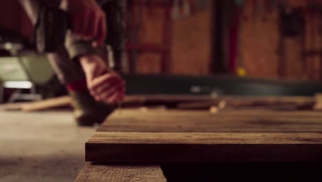 person using cordless screw driver on woodwork carpentry inside the shop