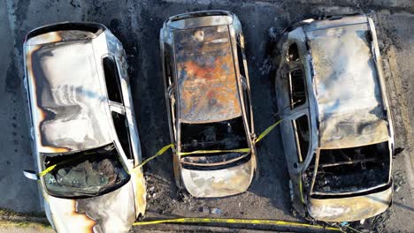 Burned-cars-in-a-city-parking,-overhead-aerial-view