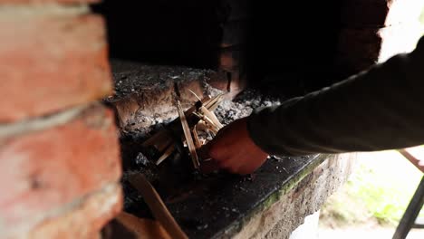 person's hand lighting a matchstick making a fire on a dirty kitchen