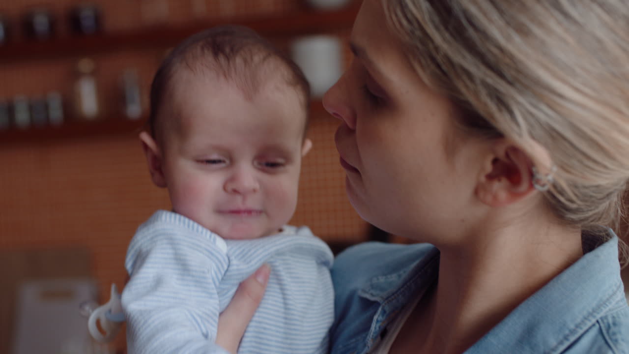 어린 어머니가 집에서 아기를 돌보는 불행한 신생아를 진정시키는 부드럽게 진정시키는 울고 있는 유아를 양육하는 모성