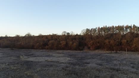 Early-morning,-the-sun-is-rising-over-the-village-and-small-forest-on-the-hill