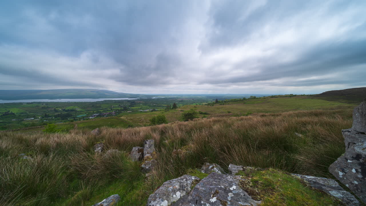 Panorama motion time lapse of rural landscape with rocky foreground and hills and lake in the distance on a spring cloudy day in Arigna mountains in county Leitrim in Ireland