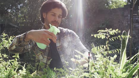 Kaukasischer-Mann-Gießt-Pflanzen-Im-Sonnigen-Garten,-Zeitlupe