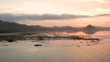 The-dry-reef-of-Kuta-Lombok-during-sunrise,-with-local-people-looking-for-food-and-seashells