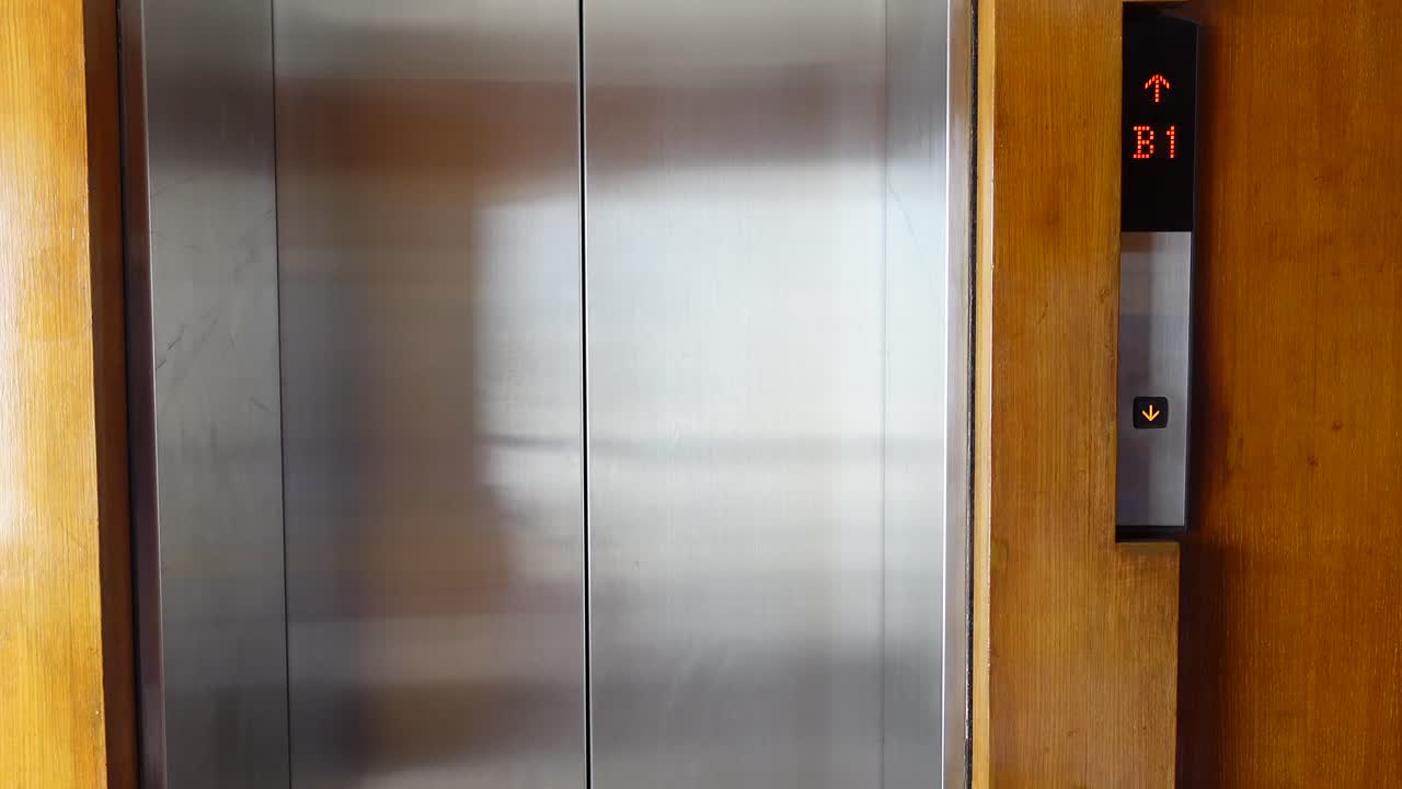 Interior de ascensor con pantalla y panel de madera