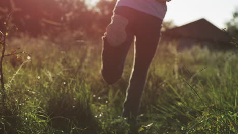 person running in a field at sunset