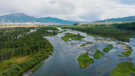 aerial view of a winding river in a forested mountain valley