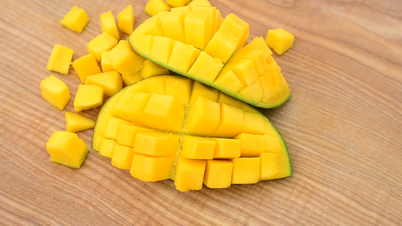 Pezzi di mango su un tagliere di legno. Riprese in movimento