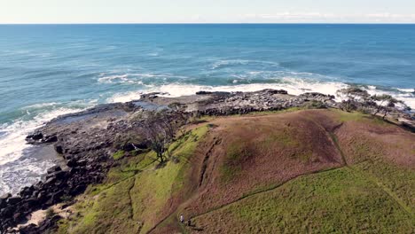 Dron-Aéreo-Pan-Shot-Ver-Paisaje-Naturaleza-Paisaje-Pareja-Gente-Para-Caminar-Sendero-Playa-Océano-Arrecife-Rocoso-Yamba-Angourie-Costa-Norte-Promontorio-Nsw-Australia-4k