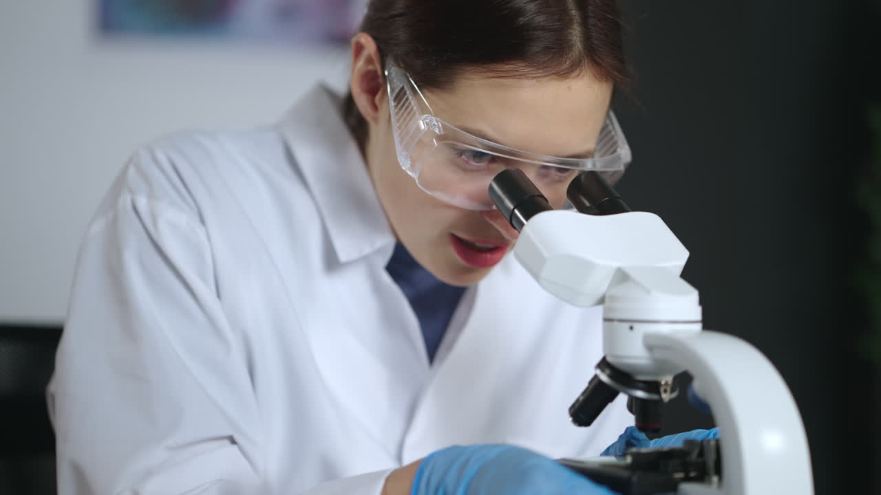 Female Scientist Using Microscope in Laboratory