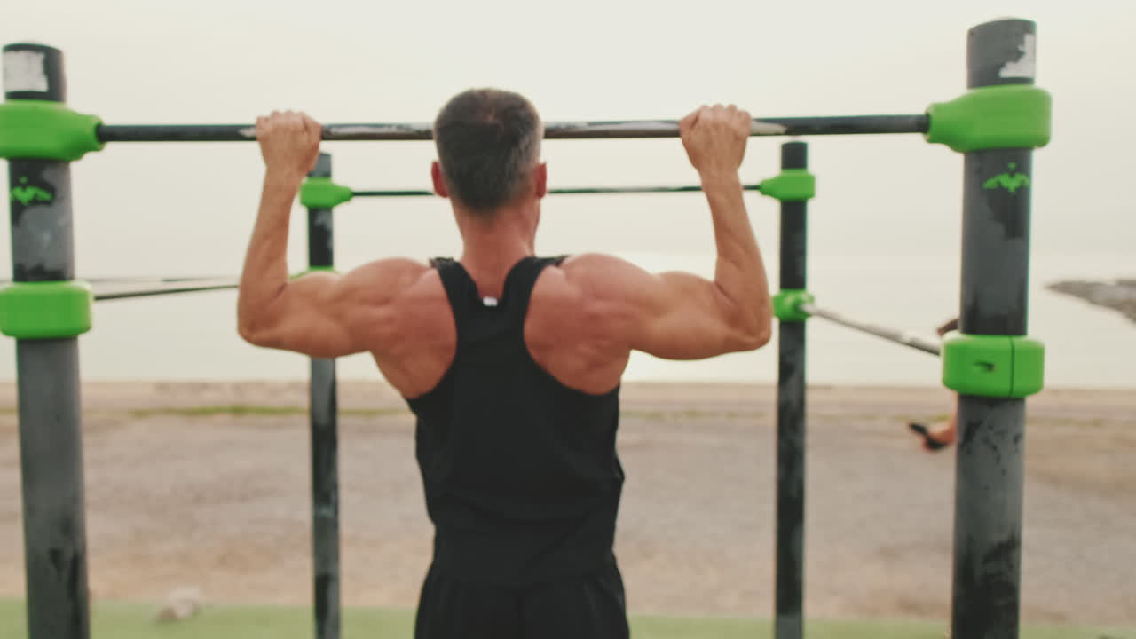 hombre haciendo pull-ups al aire libre