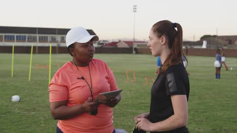 young adult female rugby player and coach at training