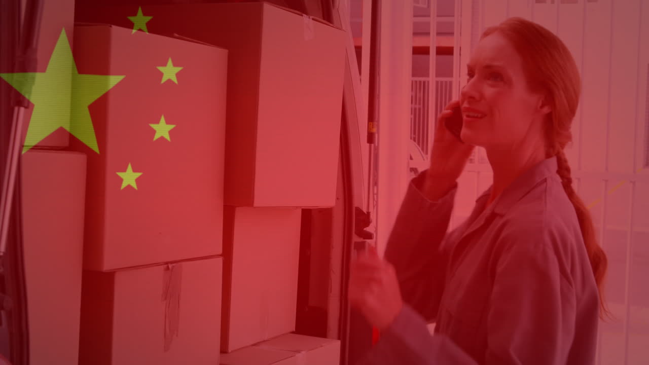 段ボール箱の隣でスマートフォンを使う女性の上に中国国旗がはためくアニメーション
