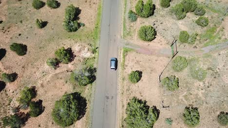Aerial-tracking-reveal-shot-of-car-driving-on-Grand-Canyon-solitary-road,-Arizona