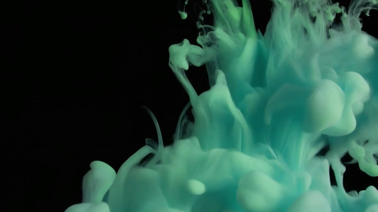 Inchiostro turchese che gocciola e si dissolve nell'acqua