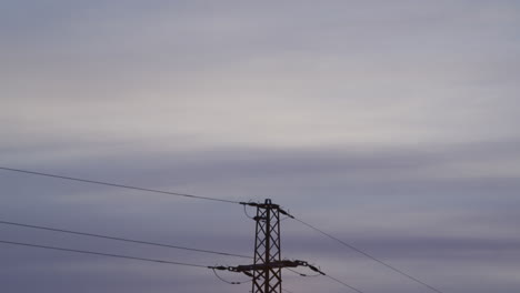 plano medio de una torre de electricidad al amanecer